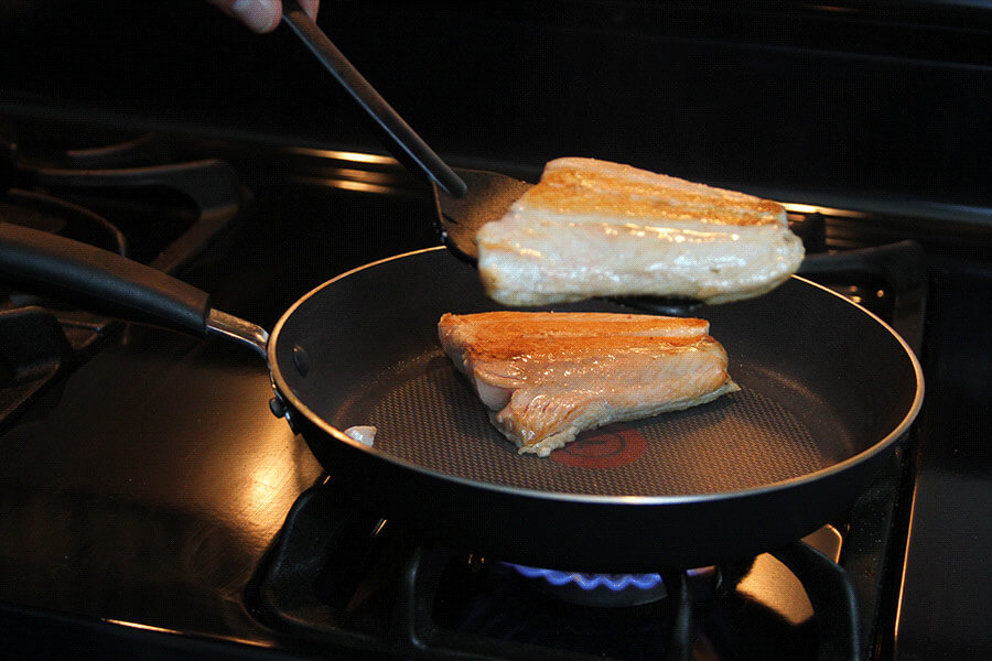 flipping salmon in a nonstick pan