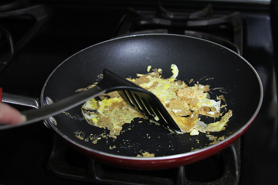 scrambled eggs stuck to the surface of a pan