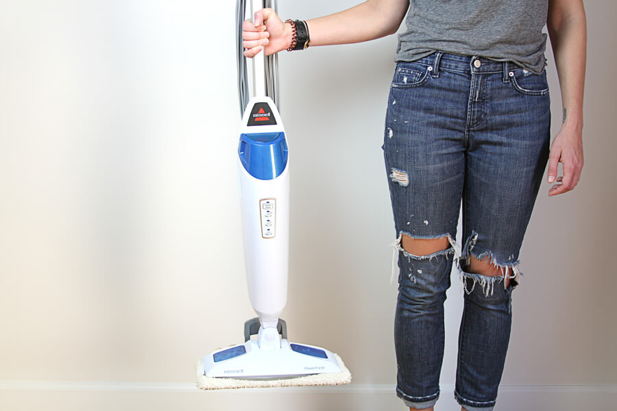 person holding a mop with one hand