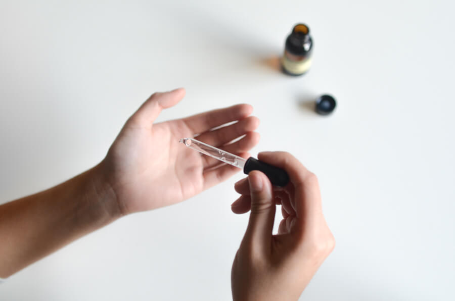 eye dropper using essential oil on hand