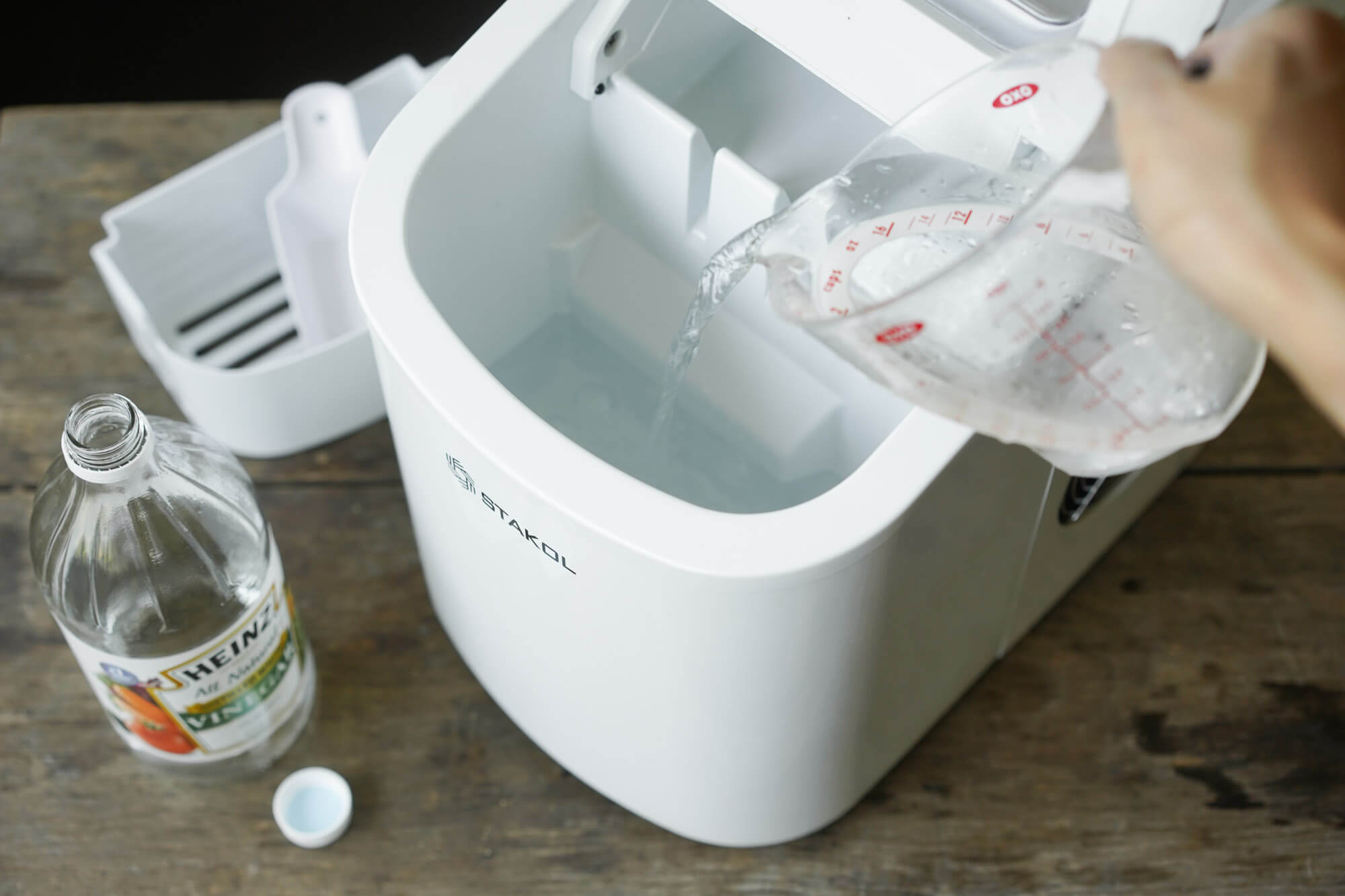 pouring cleaning solution into ice maker
