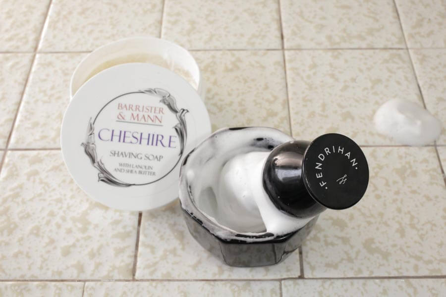 a shaving brush in a bowl of soap lather