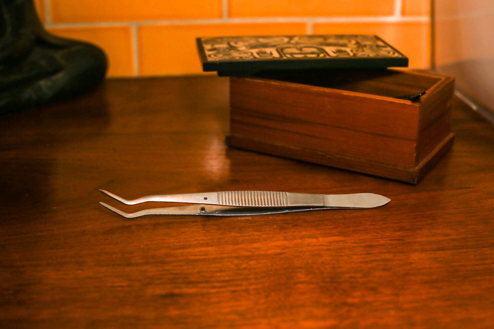 tweezier on wood background