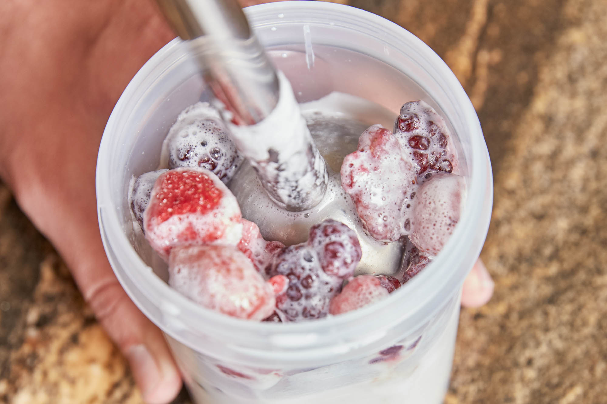 Mixing frozen fruit in a plastic cup
