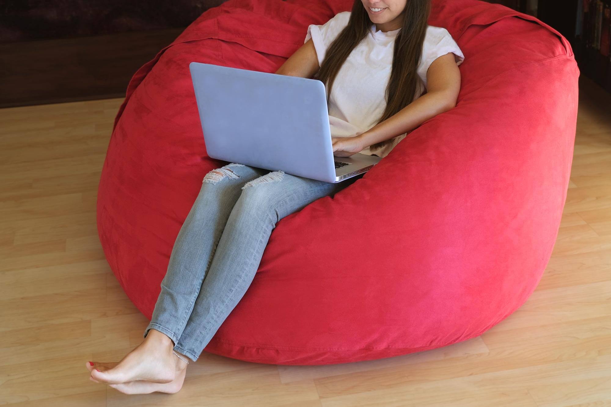 Woman sitting on bean bag doing homework