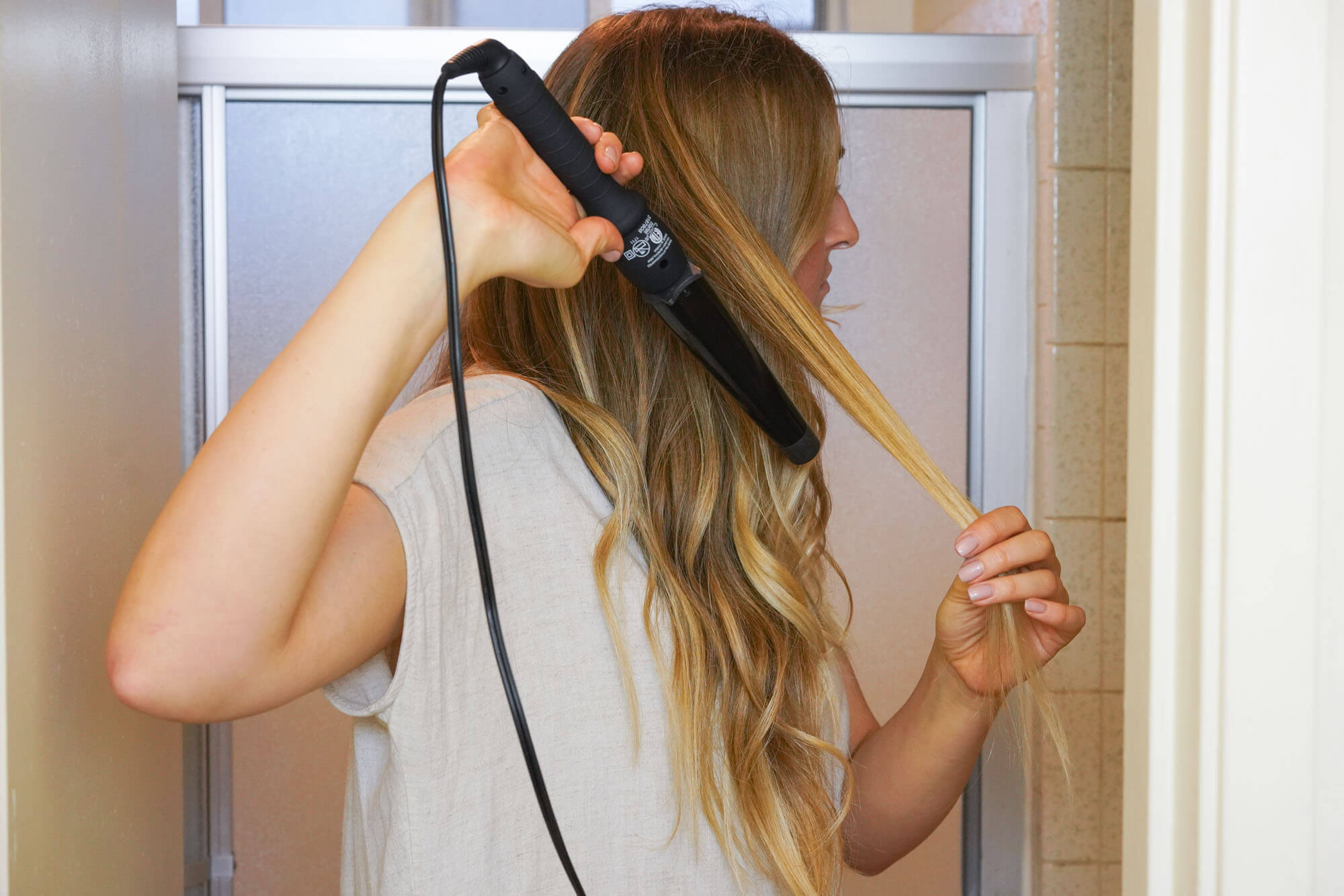 Woman using Xtava curling wand