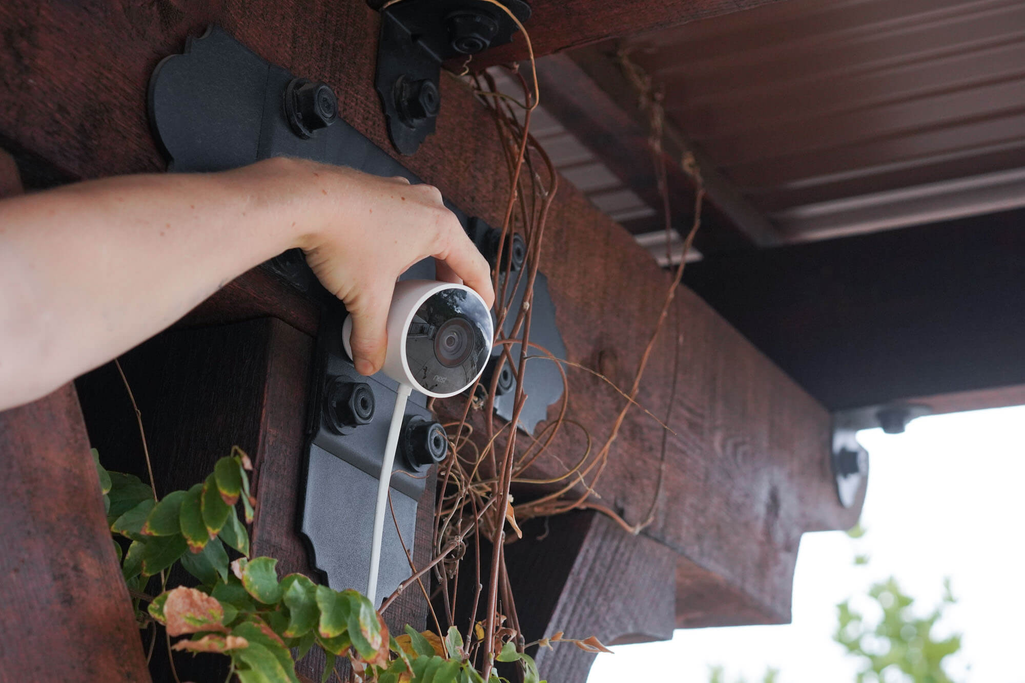 Hand adjusting Nest camera aim