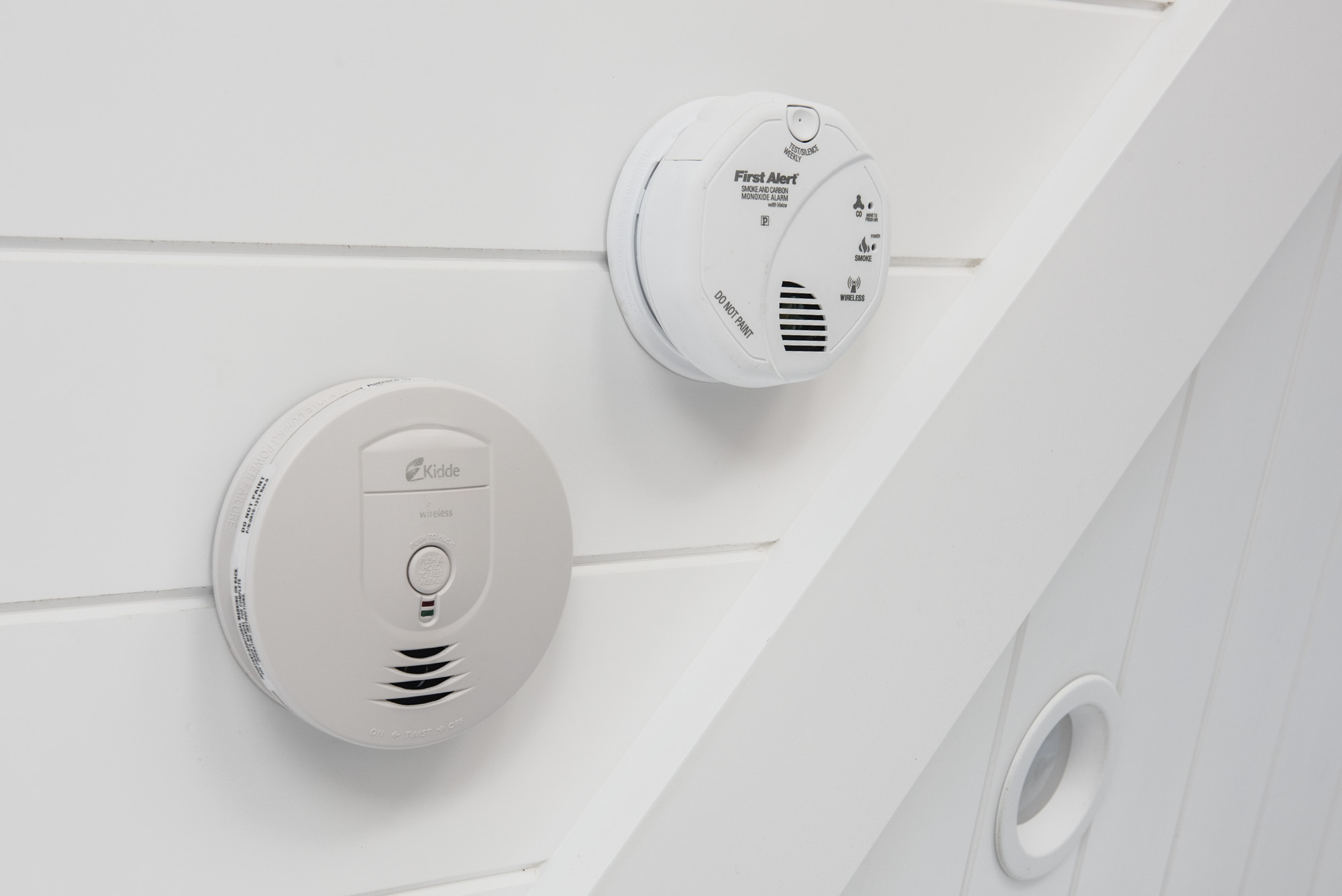 Two side-by-side smoke detectors on ceiling