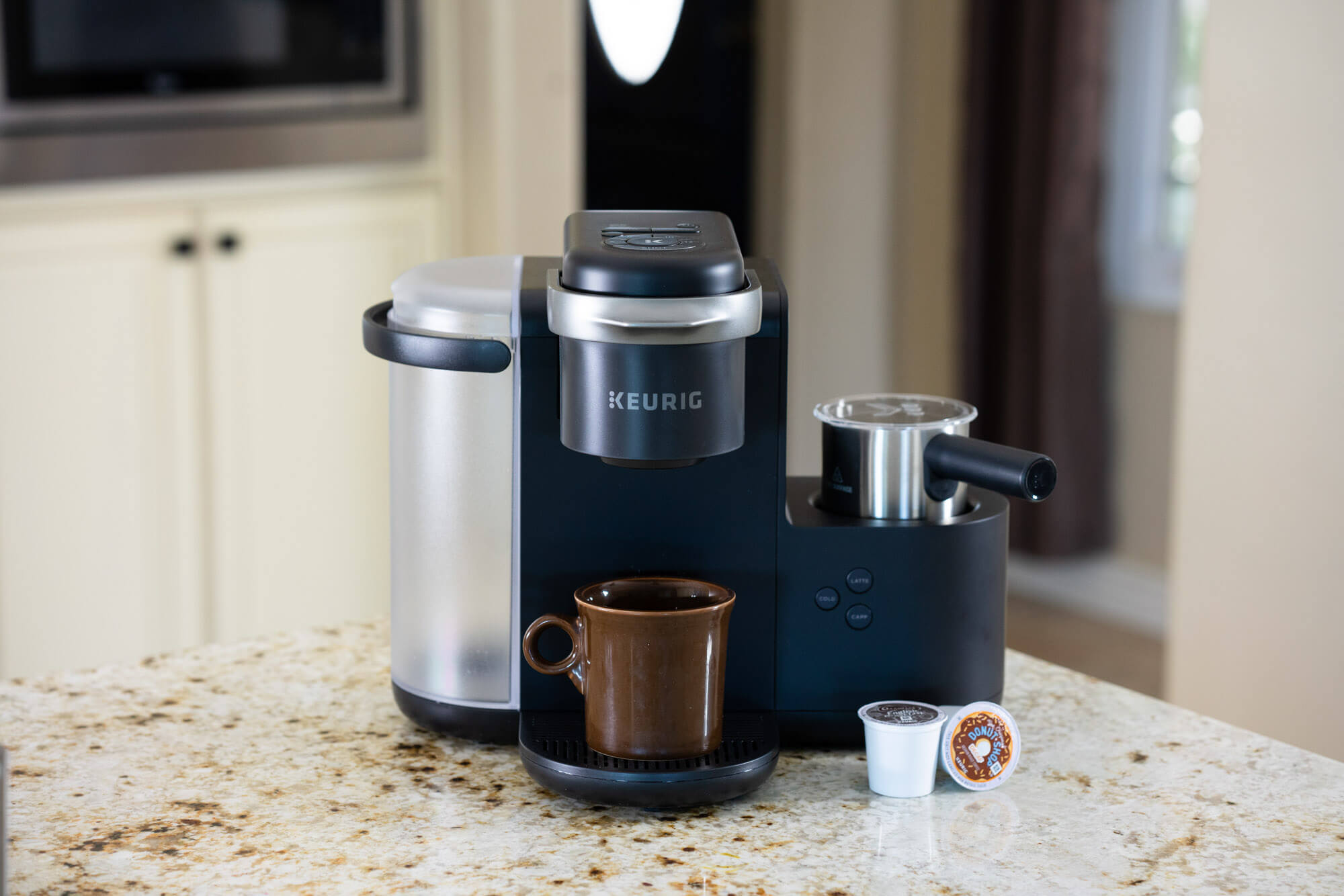 K-cafe on countertop with brown mug. 