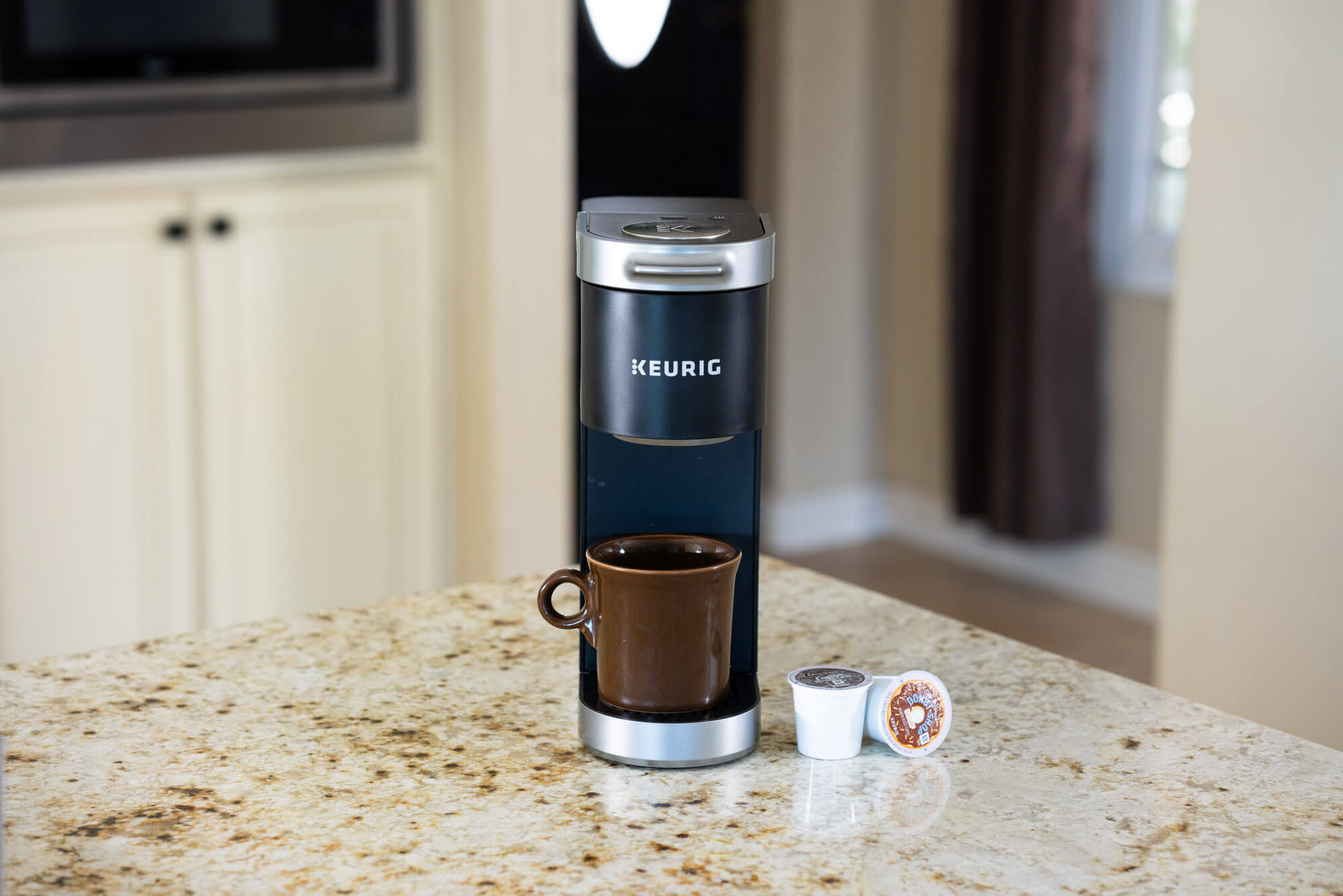 k mini plus on countertop with brown mug