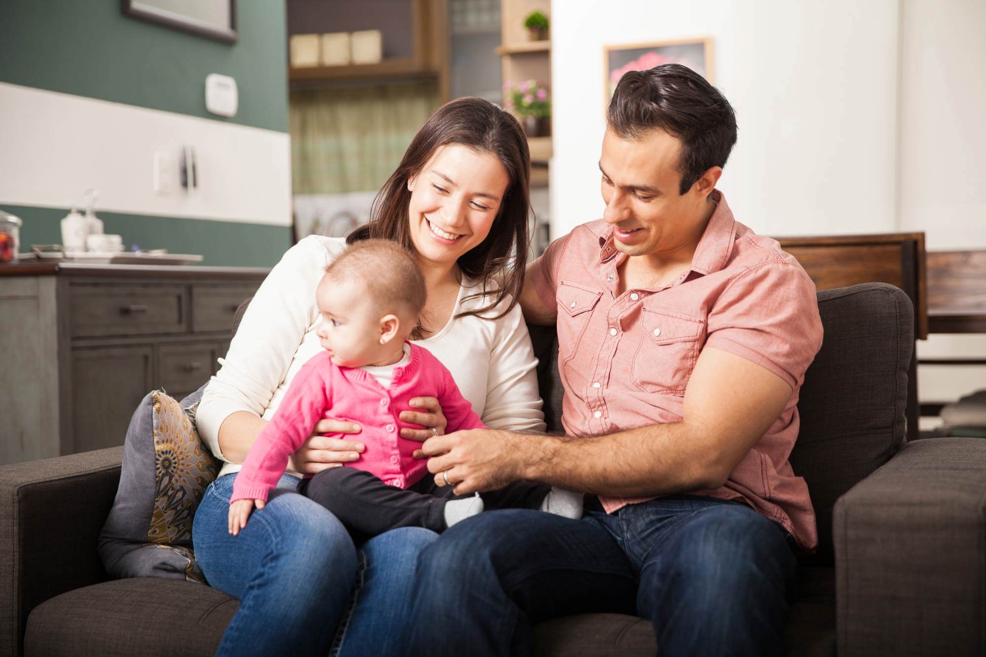 mom and dad holding baby in living room