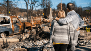 couple hugging in front of burned land