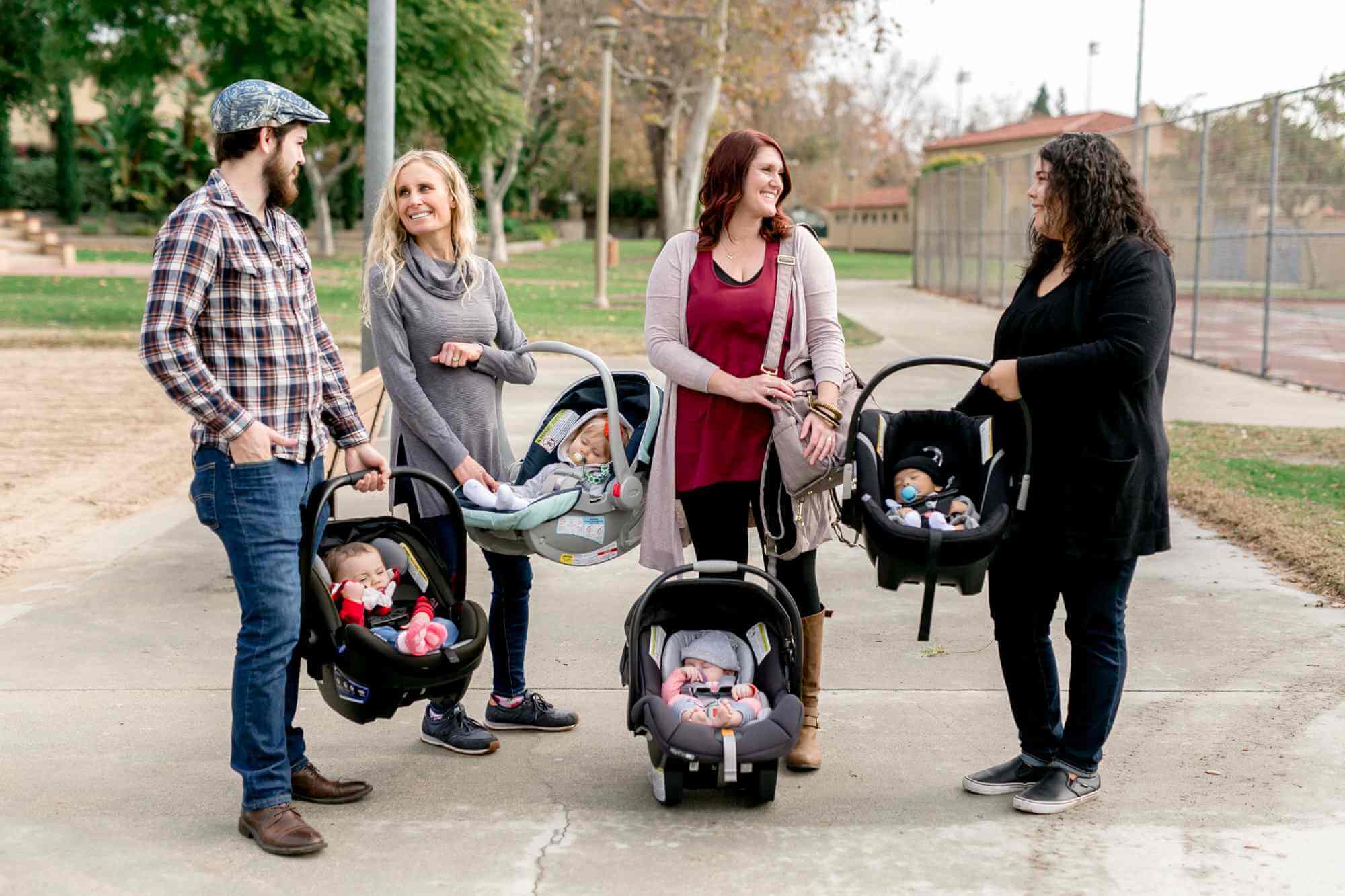 Parents holding car seats