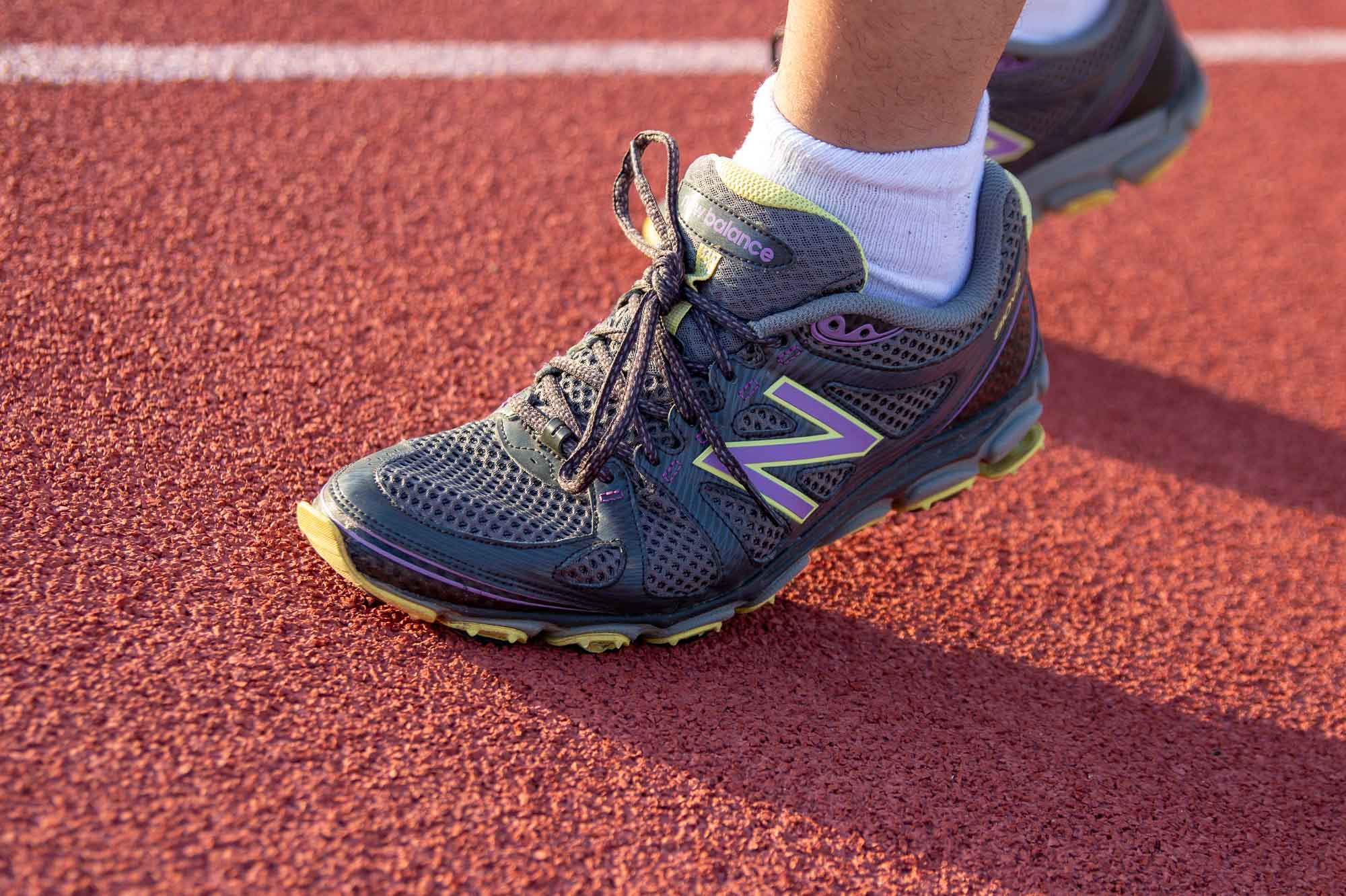 Man's feet running on track 