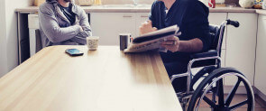 person in wheelchair reading paper