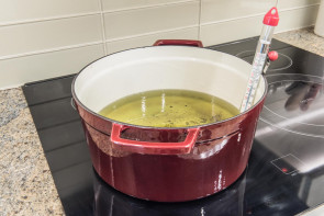 cast iron pot with frying oil and thermometer