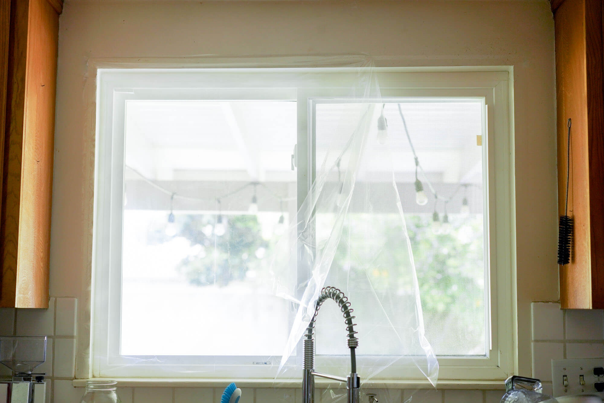 adding plastic film to a window to keep heat in