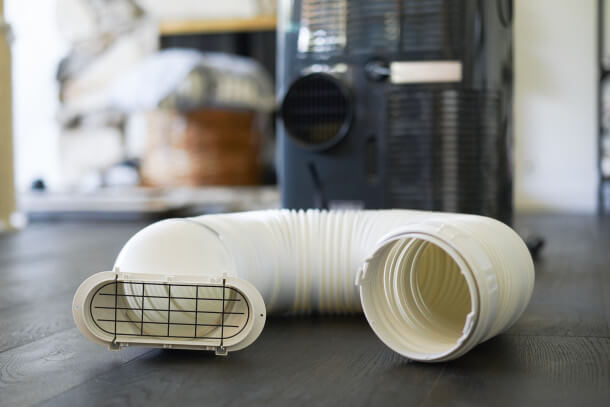 closeup of a portable AC's vent hose with wire grate