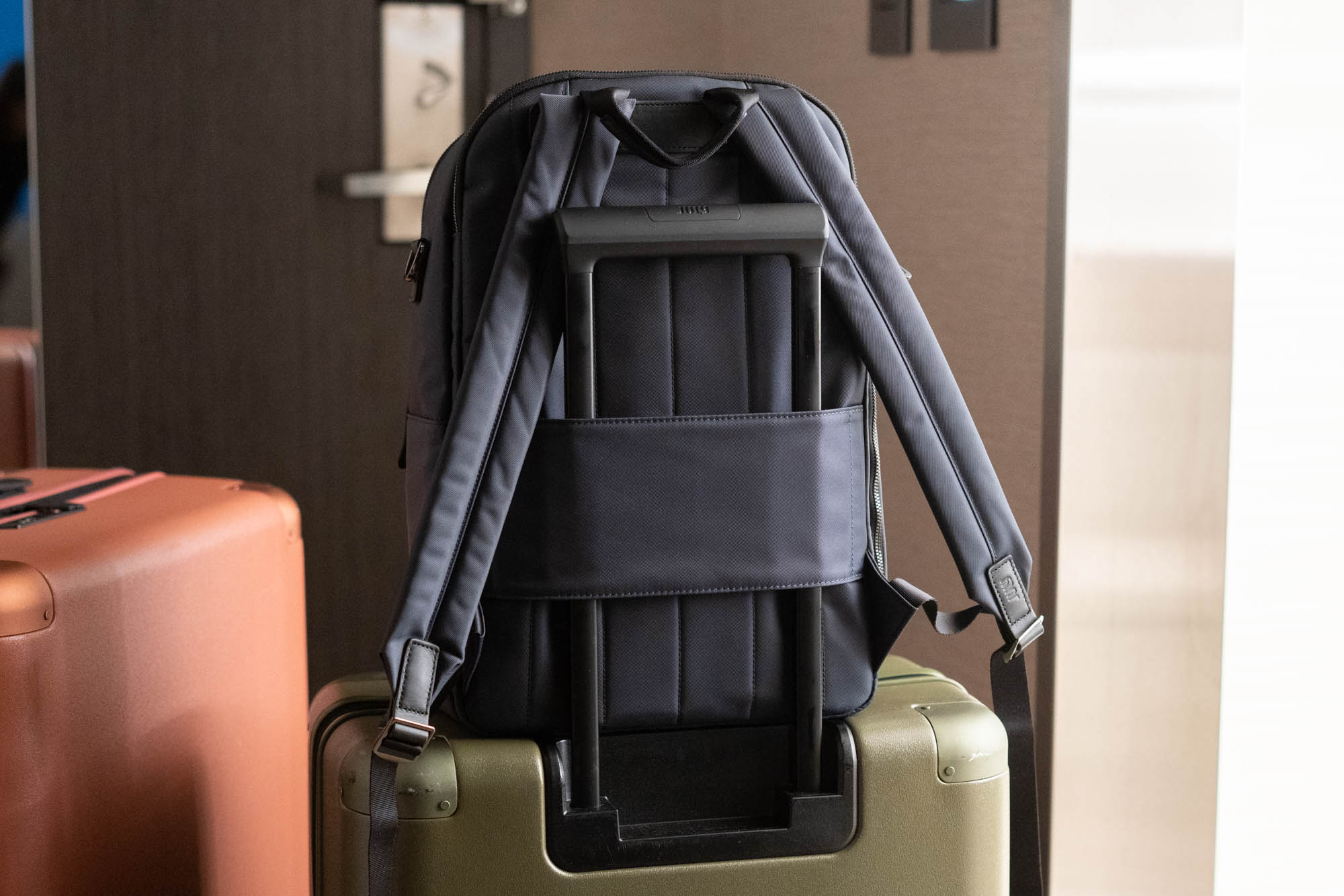 July travel backpack on suitcase